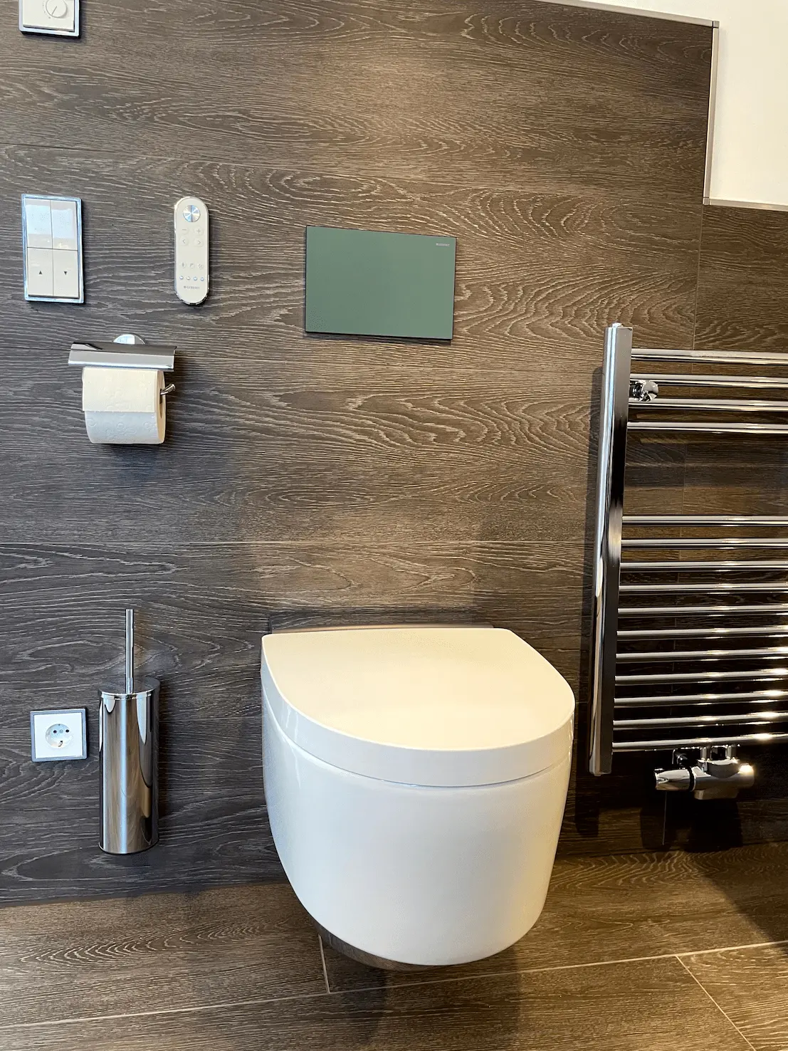 Modernes Bad mit Wand-WC, Holzoptikfliesen und Handtuchheizkörper